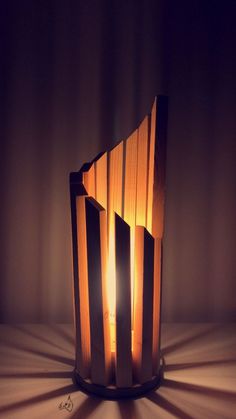 a lamp that is sitting on top of a wooden table with the light shining through it