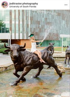 a woman sitting on the back of a bull statue