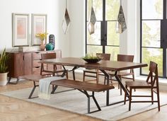 a dining room table and bench in front of large windows