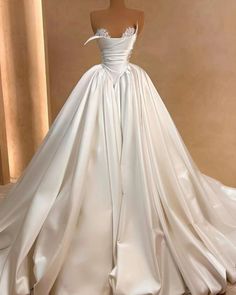 a white wedding dress on display in front of a mannequin's head