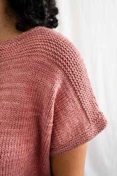 a close up of a woman wearing a pink sweater