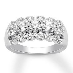 a three stone diamond ring on a white background