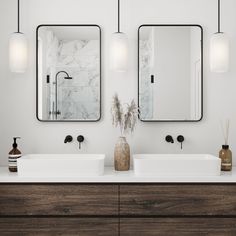 two sinks and mirrors in a bathroom with white walls, dark wood cabinets and black fixtures