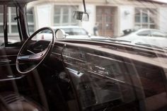 the interior of an old car parked in front of a building