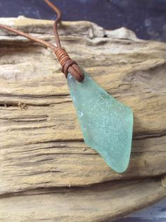 a piece of sea glass sitting on top of a piece of wood