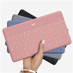 a person holding a pink keyboard in front of four different colored keyboards on top of each other