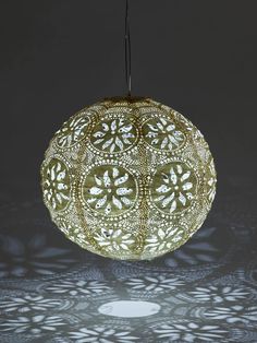 an intricately designed light fixture is shown in the dark, with shadows on it