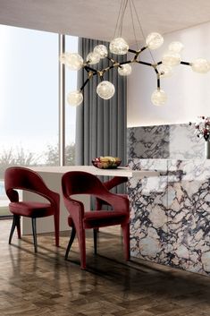 a modern dining room with marble counter tops and red chairs