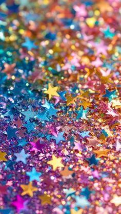 multicolored stars are scattered on the ground in this close up photo, which looks like glitter