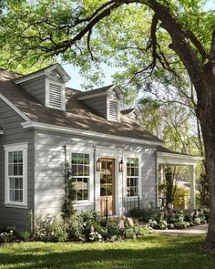 a small gray house with white windows and shutters on the front door is featured in instagram