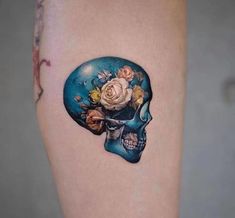 a woman's thigh with a skull and flowers on it