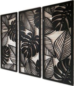 three black metal wall art pieces with leaves on the sides and one is made out of wood