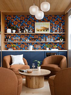 a living room with two chairs and a coffee table in front of a wallpapered bar