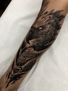 a black and white tattoo on the leg of a person with an eagle head in it