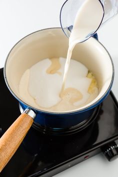 a person pouring milk into a pan on top of a stove