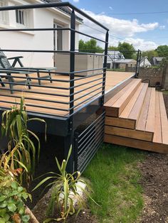 a deck with metal railing and wooden steps