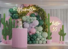 balloons and greenery are on display in front of a backdrop