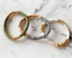 three bracelets sitting on top of a marble counter