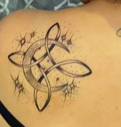 a tattoo on the back of a woman's shoulder with stars and an intertwined design