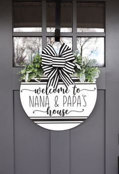 a welcome to nana and papa's house sign hanging on the front door