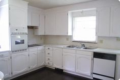 a kitchen with white cabinets and wood flooring, including a dishwasher in the center