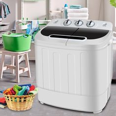 a washing machine sitting on top of a kitchen floor next to a basket filled with laundry