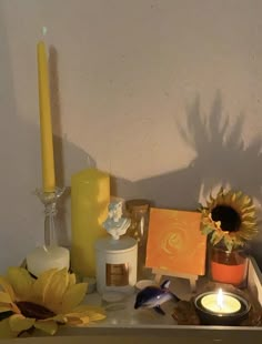 a table topped with candles and flowers next to a wall