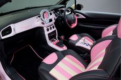 the interior of a car with pink and black leather trims, steering wheel cover and dash board