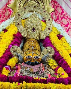 an idol is shown in the middle of a stage with flowers and decorations around it