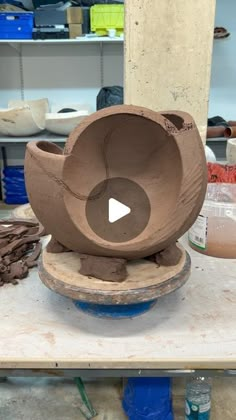 a clay bowl sitting on top of a table next to other pottery items in a room