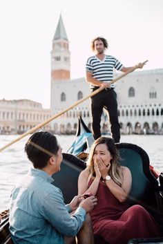 a man and woman sitting in a gondola on the water with one holding her mouth open