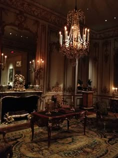 an ornate living room with chandelier and fireplace