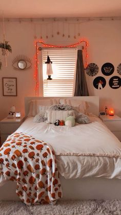 a white bed sitting in a bedroom next to a window with orange lights on it