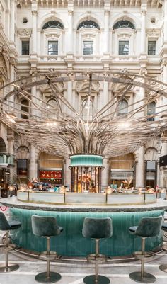 the inside of a building with many chairs and tables in front of an indoor fountain