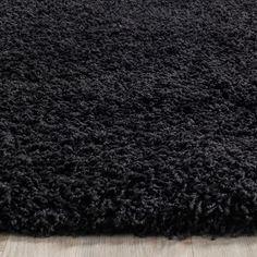 black shaggy rug on wooden floor in room