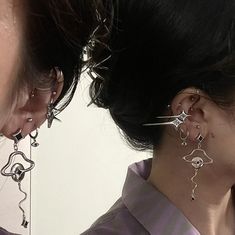 the woman is wearing ear piercings and looking at her reflection in the mirrored mirror