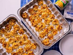 two pans filled with food sitting on top of a blue and white table cloth