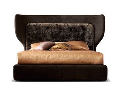 a bed that has some pillows on it and is made up with brown leather furniture