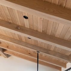 the ceiling is made out of wood and has two lights hanging from it's sides