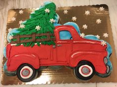 a red truck with a christmas tree on the back is sitting on a gold plate