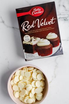 a box of red velvet next to a bowl of cupcakes