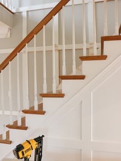 a driller sitting on the ground in front of a stair case