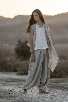 "Meet our relaxed Linen Harem Pants from the \"Desert Hues: Agender Linen Collection.\" These gender-neutral adult pants are all about easy-breezy style, taking inspiration from the calming shades of the desert. Created from soft, breathable linen, these pants are your go-to choice for both comfort and fashion, especially in the hot weather. The fabric's natural texture adds an authentic touch, reflecting the raw beauty of the desert sands. Choose from three natural shades:  1. Classic Natural Flax Color - made of lightweight linen, these pants are the lightest in this collection. 2. Natural Flax and White Melange - made of medium-weight linen. 3. Natural Flax and Gray Melange - made of medium-weight linen, but a little bit heavier and good for the cooler weather.  These natural linen pant Flax Outfits, Nonbinary Fashion Feminine, Desert Clothes, Cycle Breakers, Desert Clothing, Natural Linen Pants, Nomad Fashion, Sarouel Pants, Flax Pants