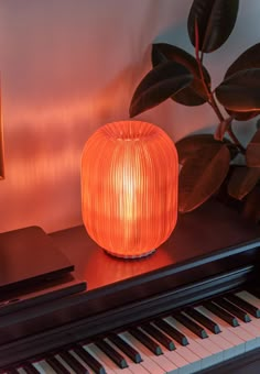 an orange lamp sitting on top of a piano