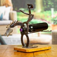 a wooden table with a wine bottle holder on it and a statue of a horse