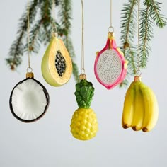 an assortment of fruit ornaments hanging from a christmas tree with pineapple, banana and kiwi