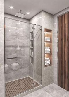 a bathroom with a walk in shower next to a white toilet and wooden shelves on the wall