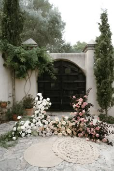 an outdoor area with flowers and plants on the ground