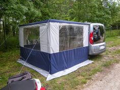 a van is parked next to a tent in the grass with its back door open