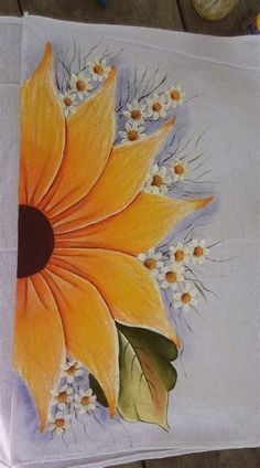 a painting of a yellow flower on a white table cloth with flowers in the center